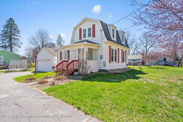 dutch colonial featuring a garage, an outbuilding, a gambrel roof, and a front lawn