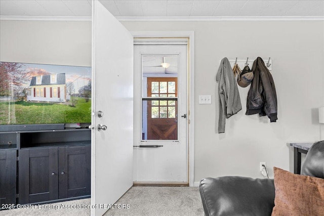 entryway featuring light colored carpet, baseboards, and crown molding