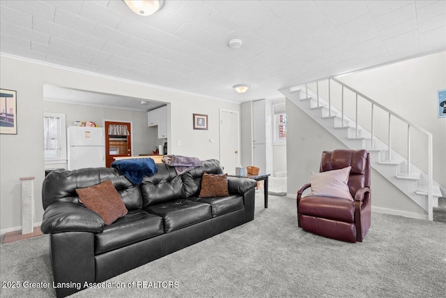carpeted living area featuring baseboards, stairway, and crown molding