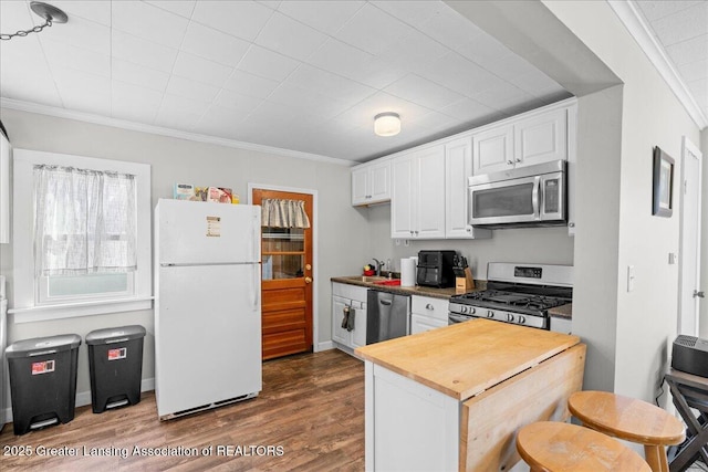 kitchen with crown molding, a sink, wood counters, stainless steel appliances, and dark wood-style flooring