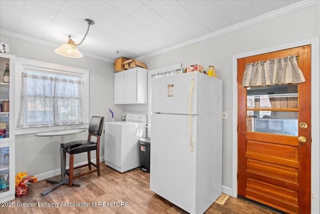 kitchen with white cabinets, wood finished floors, freestanding refrigerator, and washer / dryer