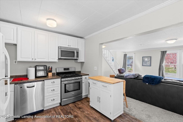 kitchen featuring stainless steel appliances, white cabinetry, and ornamental molding