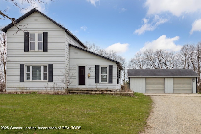traditional-style home with an outbuilding, a detached garage, and a front yard