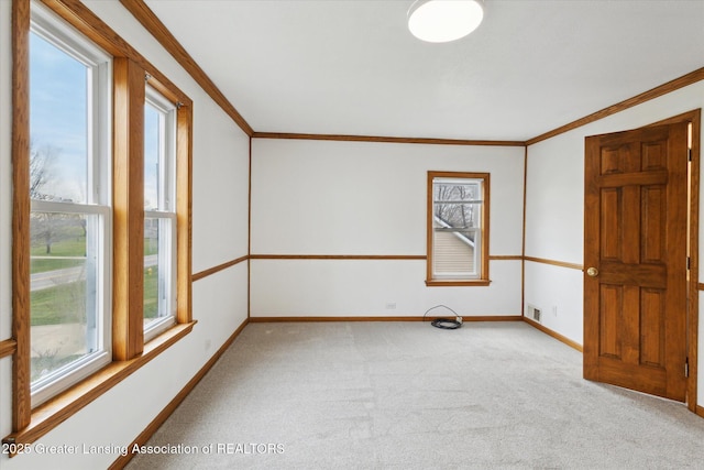 empty room featuring visible vents, ornamental molding, baseboards, and light carpet