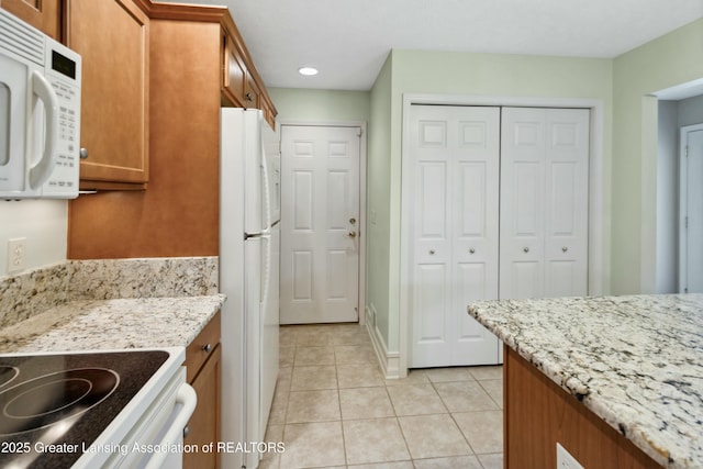 4163 Hamlet Cv, Bath, MI 48808 - kitchen with brown cabinetry, white appliances, recessed lighting, light tile patterned floors, and light stone countertops