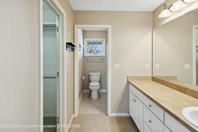 4163 Hamlet Cv, Bath, MI 48808 - full bathroom with toilet, vanity, tile patterned flooring, a walk in closet, and baseboards