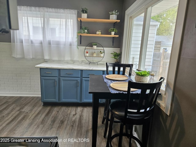 2032 Hillcrest St, Lansing, MI 48910 - kitchen featuring dark wood-style floors, blue cabinetry, light stone counters, and open shelves