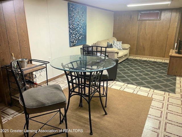 2032 Hillcrest St, Lansing, MI 48910 - dining area with tile patterned floors, baseboards, a wall mounted air conditioner, and wood walls