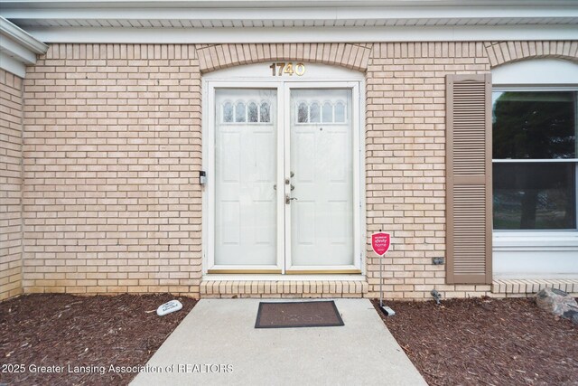 view of exterior entry featuring brick siding