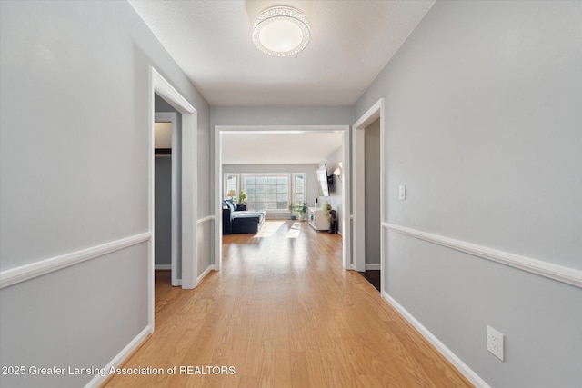 hall with light wood finished floors and baseboards