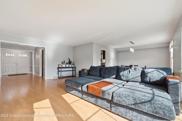 living room with baseboards, wood finished floors, and visible vents