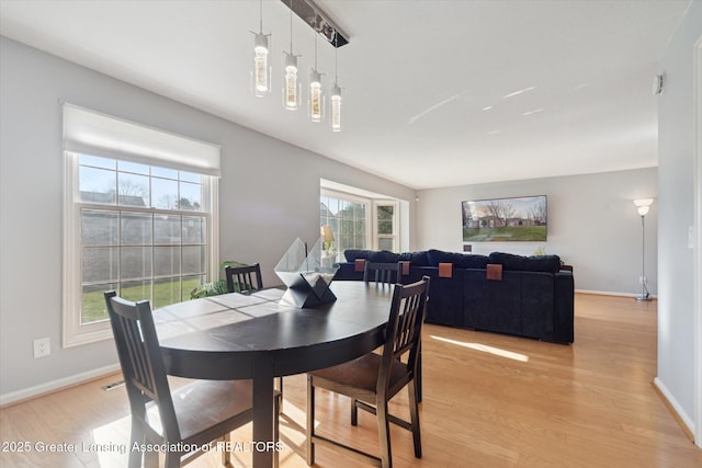 dining area featuring baseboards and light wood finished floors
