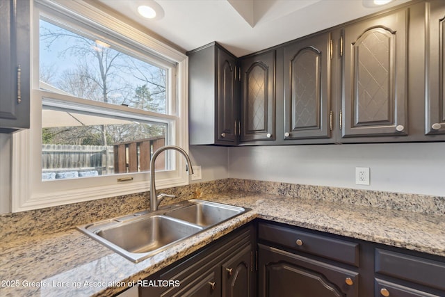 kitchen with dark brown cabinetry and a sink