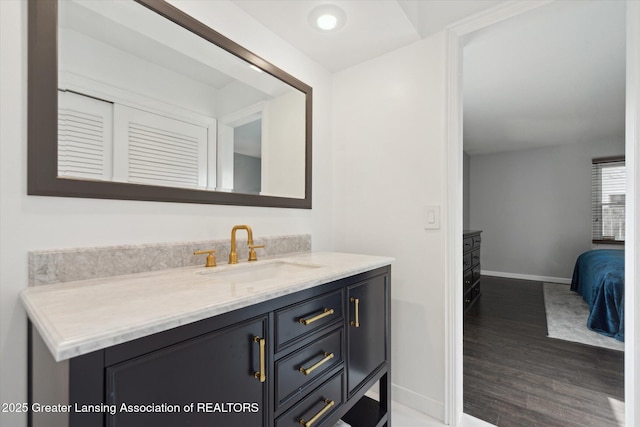 bathroom featuring wood finished floors, vanity, and baseboards