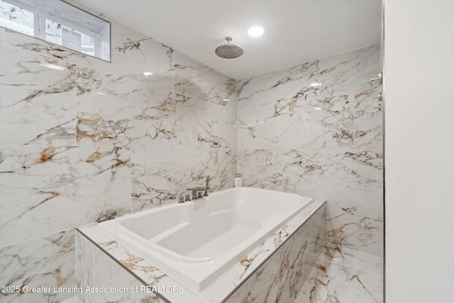 bathroom with marble finish floor, a tub with marble appearance, and a marble finish shower
