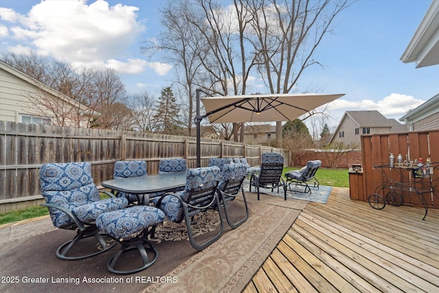 wooden deck with outdoor dining space and a fenced backyard