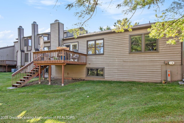 rear view of house with stairway, a wooden deck, and a yard