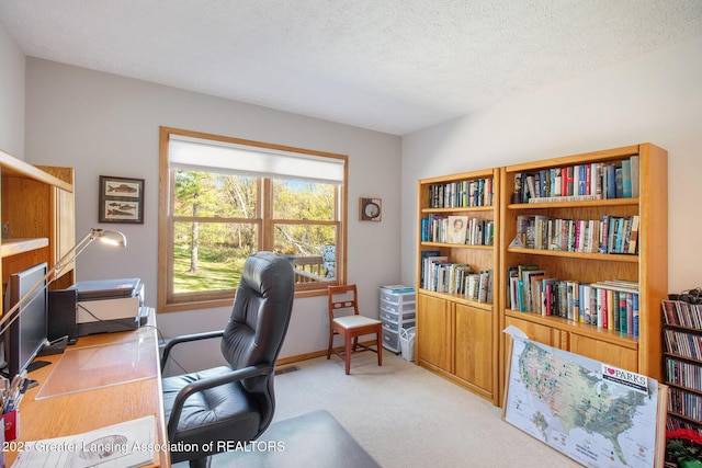 carpeted office with a textured ceiling