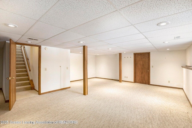 finished basement featuring stairs, a drop ceiling, light carpet, visible vents, and recessed lighting