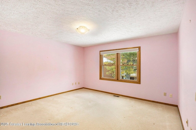 carpeted empty room with a textured ceiling, baseboards, and visible vents