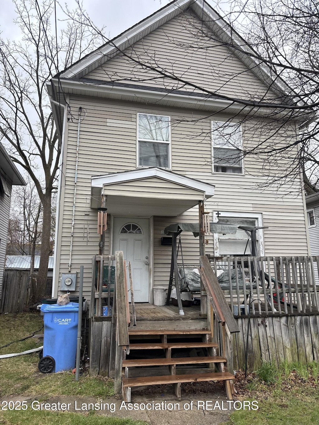 view of front of house featuring a deck and fence
