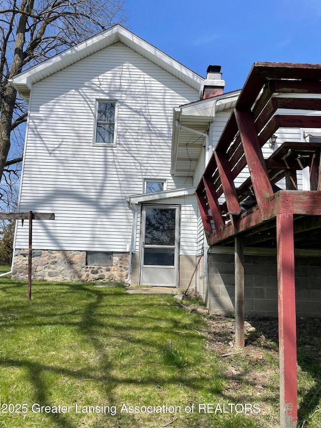 rear view of house with a lawn and a chimney