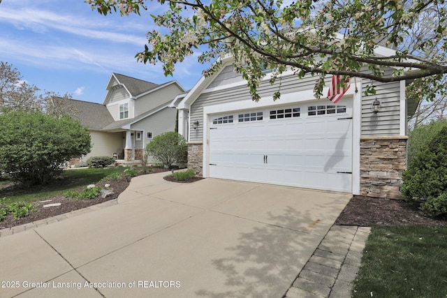 view of front of house featuring concrete driveway, an outbuilding, and stone siding
