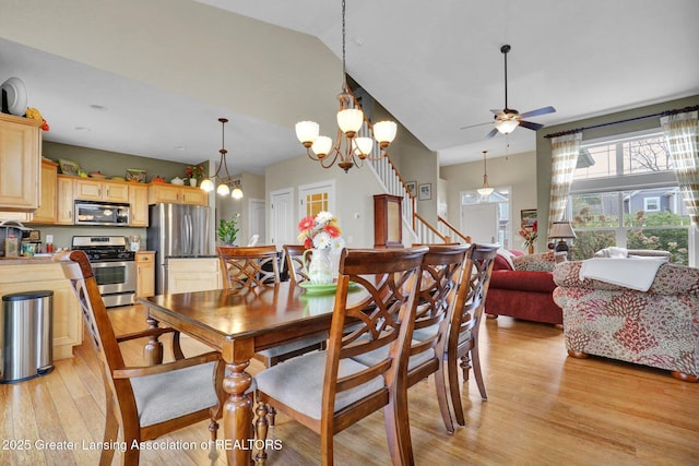 dining room featuring light wood finished floors and ceiling fan with notable chandelier