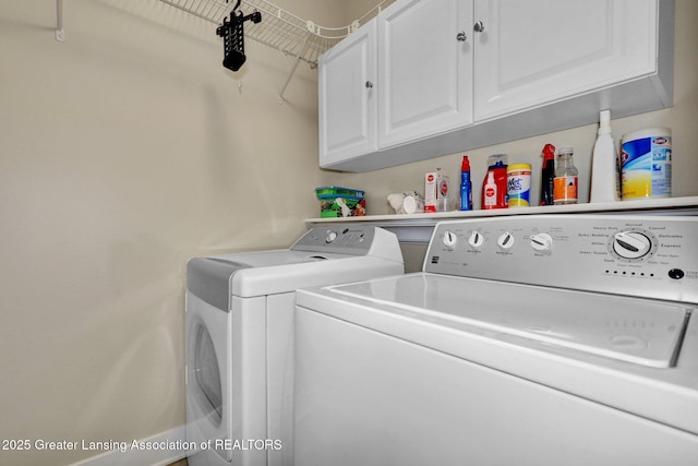 clothes washing area with washer and clothes dryer and cabinet space