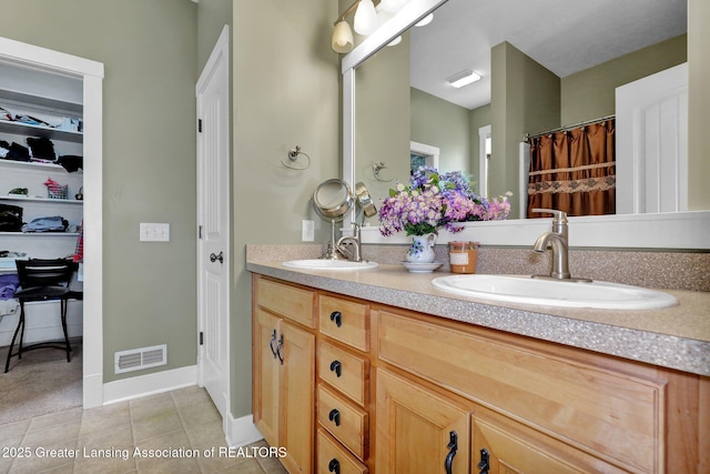 bathroom featuring a sink, tile patterned flooring, double vanity, and visible vents