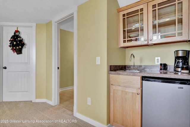 bar featuring light carpet, a sink, baseboards, wet bar, and dishwashing machine