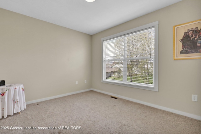 carpeted spare room with baseboards and visible vents