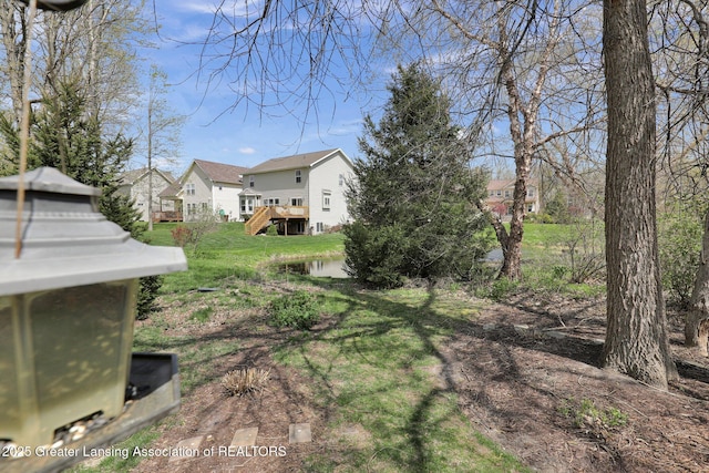 view of yard with a residential view, a deck, and stairway