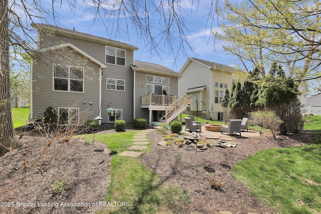 rear view of property featuring stairs, a fire pit, and a wooden deck