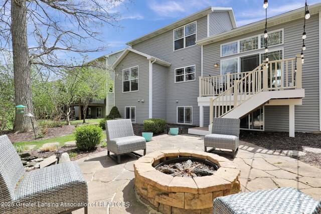 back of house featuring a wooden deck, a fire pit, a patio area, and stairway