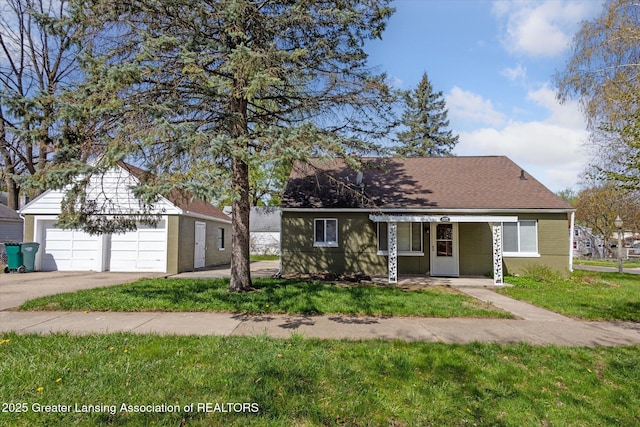 view of front of property featuring a garage, an outbuilding, driveway, and a front lawn