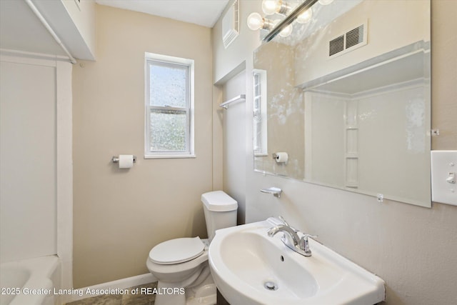 bathroom with visible vents, toilet, a washtub, baseboards, and a sink
