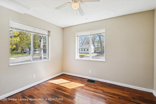 empty room with baseboards, visible vents, and a wealth of natural light