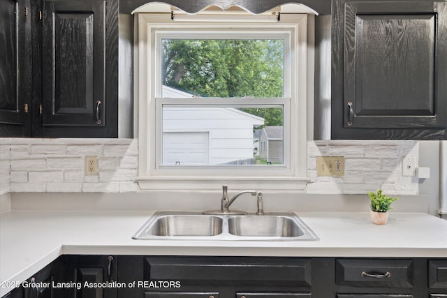 3427 W Jolly Rd, Lansing, MI 48911 - kitchen with dark cabinets, light countertops, and decorative backsplash