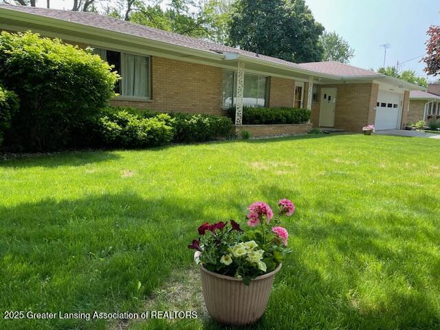 505 S Baker St, Saint Johns, MI 48879 - ranch-style home with a garage, brick siding, and a front lawn