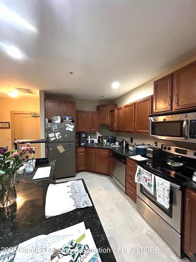 kitchen featuring dark countertops, appliances with stainless steel finishes, and visible vents