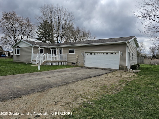 single story home with a front yard, a wooden deck, an attached garage, and aphalt driveway