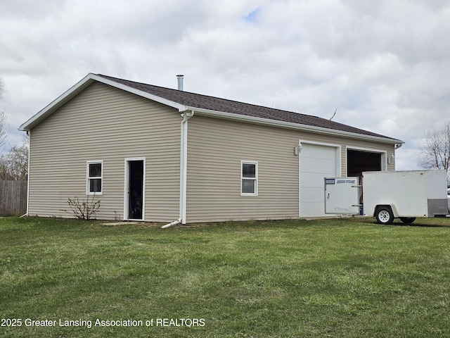 exterior space with a garage and a lawn