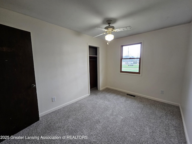 unfurnished bedroom with visible vents, a closet, baseboards, carpet floors, and a ceiling fan