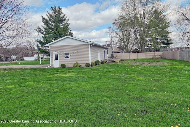 exterior space with fence, a deck, and a yard