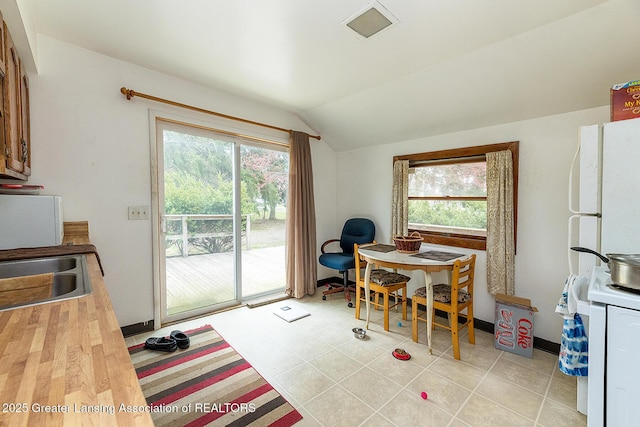 dining area with healthy amount of natural light, lofted ceiling, and baseboards