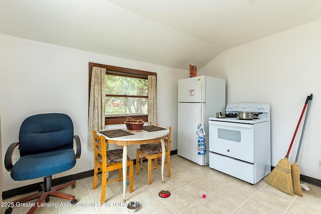 kitchen with white appliances, vaulted ceiling, and light tile patterned flooring