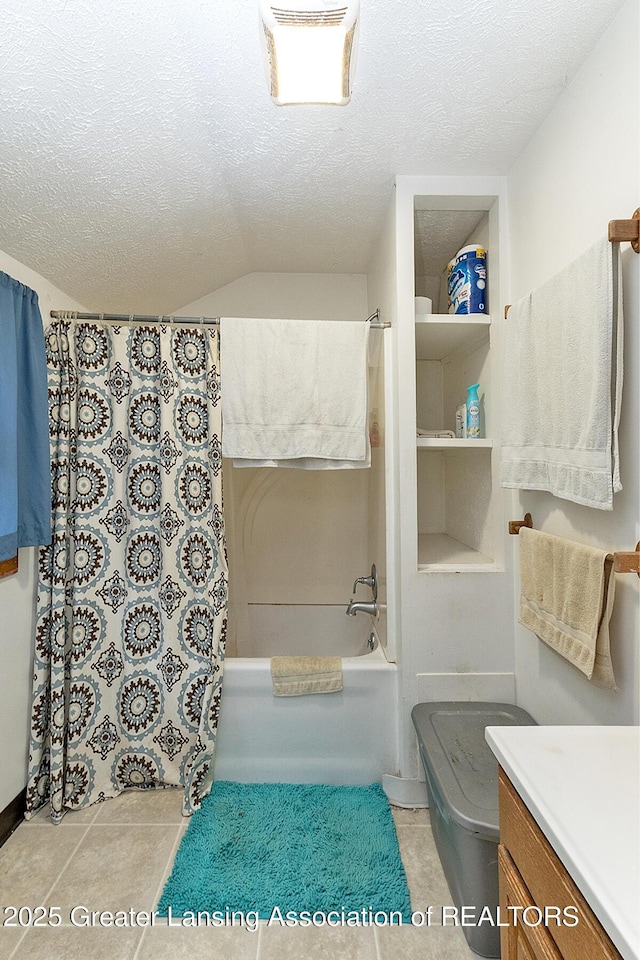 full bathroom with vanity, a textured ceiling, shower / bath combo with shower curtain, and tile patterned floors