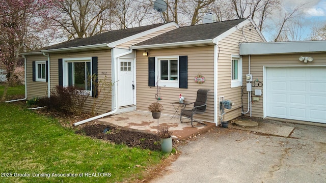 view of front of property featuring a chimney, aphalt driveway, and a garage