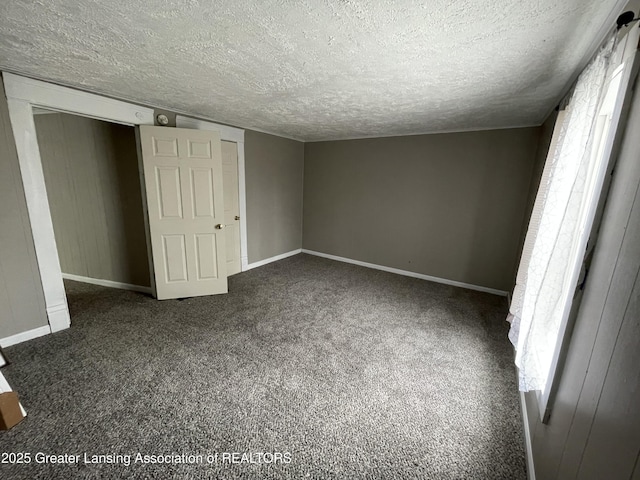 325 N Pennsylvania Ave, Lansing, MI 48912 - unfurnished bedroom featuring carpet floors, a textured ceiling, multiple windows, and baseboards